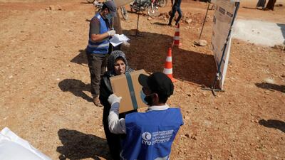 An internally displaced Syrian woman receives a parcel of humanitarian aid in the opposition-held Idlib, Syria. Reuters