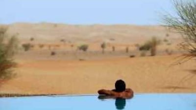 A visitor looks out over the desert at Al Maha resort, an upmarket 40-room resort in the Dubai Desert reserve, one of the few boutique hotels in the country.