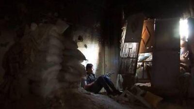 A Free Syrian Army fighter sits near sandbags inside a damaged room in Deir Al Zor. Many young fighters are disillusioned with the revolution and unsure about the purpose of fighting on.