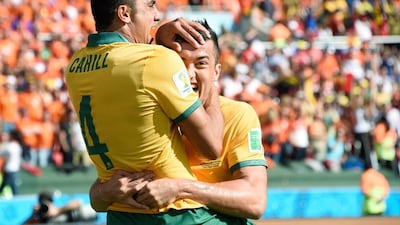 Tim Cahill celebrates with a teammate after scoring Australia's first goal on Wednesday against the Netherlands in their 2014 World Cup Group B match in Porto Alegre, Brazil. Juan Barreto / AFP