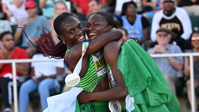 Women's 100m hurdles gold medallist Tobi Amusan hugs women's long jump silver medallist Ese Brume. AFP
