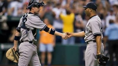 New York Yankees catcher Chris Stewart, left, congratulates closer Mariano Rivera after another successful save.