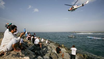 Spectators watch the capsized Austarlia Team boat as winners, Victory Team race by during the Fujairah Grand Prix. Mike Hewitt / Getty Images
