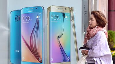 A woman walks past a billboard of the Samsung Galaxy S6 and S6 edge at a shop in Seoul. AFP