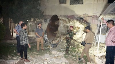 Residents and investigators at the scene of a gas tanker explosion in Baghdad. AFP