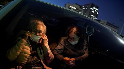 An elderly woman adjusts her mask as she waits for a movie to start at a drive-in theatre temporarily set up for residents following the outbreak of the coronavirus. Reuters