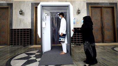 A man wearing a face mask passes through a sanitisation system that has been installed at Al Farooq Omar Bin Al Khattab Mosque in Dubai. Getty Images