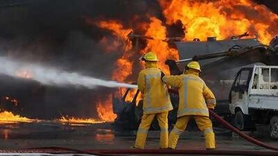 Firemen battle the fire at a diesel workshop in Musaffah yesterday.