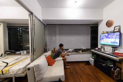 Finance worker Adrian Law eats a delivered meal while watching television in his studio apartment, for which he paid more than $765,000 USD two years ago in a new development in the gentrified Sai Ying Pun neighbourhood of Hong Kong. Anthony Wallace / AFP