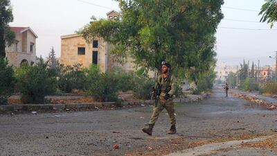 Rebel fighters walk on an empty street in the Dahiyet Al Assad district in weat Aleppo after they took control of it on October 29, 2016. Ammar Abdullah / Reuters