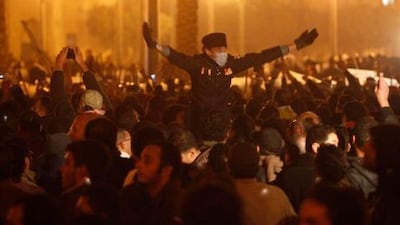 An anti-government demonstrator calls out to other demonstrators to gather before midnight in downtown Cairo.