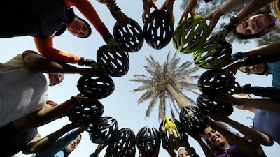 Members of a social cycling club, 'Cycling Bees', show off their cycling helmets before their ride in Manama, Bahrain. Reuters
