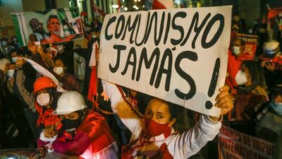 A protester holds a banner that reads "Communism Never!" as radical right-wing activists attempt to march to the Government Palace in Lima.