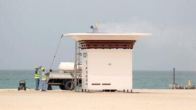 People clean the buildings on the public beach, Dubai. Chris Whiteoak / The National