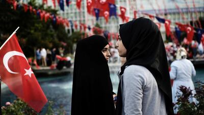 FIle photo of two young women in headscarves attending a pro-government demonstration outside the city hall in Istanbul. Turkey's army is lifting a historic ban on female officers wearing the Islamic headscarf in the officially secular country, the state-run Anadolu news agency said on February 22, 2017. Aris Messinis/AFP