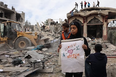 A Palestinian boy with a drawing unearthed from the rubble of a building at the site of an Israeli bombardment on Rafah, in southern Gaza. AFP