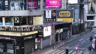 Pedestrians walk past shuttered stores on Queens Road, Central district the day after the government announced the newly imposed ban on masks. Bloomberg