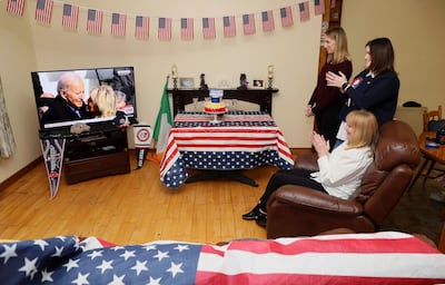 Veronica McKevitt, seated, a distant cousin of President Joe Biden, and her family applaud at their home in Ireland as they watch the US presidential inauguration. AP