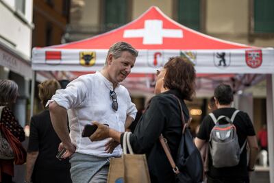 Electoral Swiss People's Party leader Marco Chiesa speaks with a woman at a booth of the right-wing populism party in Lugano. AFP