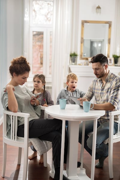 Parents should limit their use of mobile phones, as well as discourage their children from overuse of their devices. Getty Images