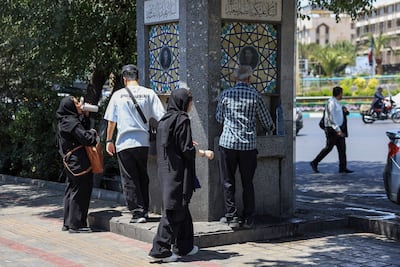 People drink water from a public fountain in Tehran. Pipes have already been running dry overnight in some areas of the city, reports say. AFP