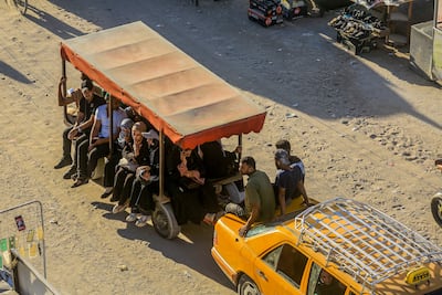 Palestinians travel in an open trailer drawn by a car in Khan Younis, southern Gaza. AFP