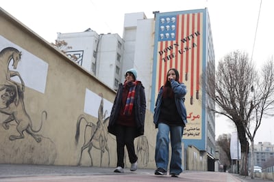 People walk next to an anti-US mural on a street in Tehran. Reuters