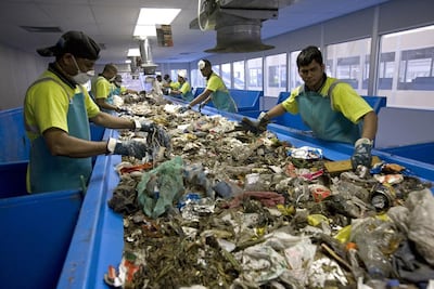 Workers sift through rubbish from landfill to separate recyclables. The new recycling banks aim to reduce this process. Jeff Topping / The National