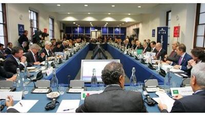 Front: G20 finance ministers pose for photographers at the G20 finance ministers meeting at the HM Treasury in London. Chris Ratcliffe / Bloomberg. Above: Participants in the G20 Finance Ministers meeting prepare for the meeting to start.