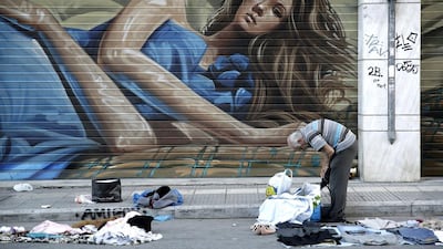 A street vendor collects his clothes outside the shutters of a shop in central Athens on May 13. Petros Giannakouris / AP Photo