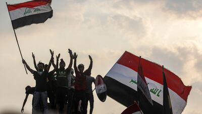 Iraqis wave national flags during a demonstration along Al Jumhuriya Bridge in Baghdad. AFP