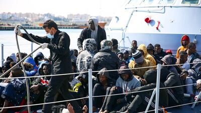 Rescued migrants sit aboard a Libyan coastguard vessel upon its arrival at the capital Tripoli's naval base. AFP.