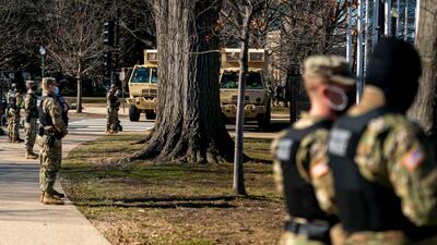 Military police and trucks stand on guard near the Capitol Building on Capitol Hill in Washington on January 14, 2021. AP
