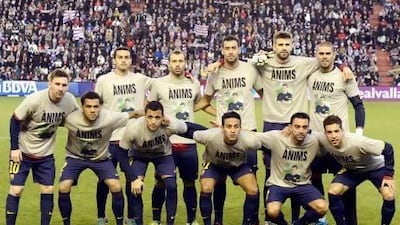 Barcelona's players pose jerseys featuring the portrait of their head coach, Tito Vilanova, reading 'Come on!', in Catalonian, prior to their Primera Liga match with Valladolid.