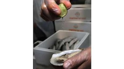 Lemon juice is dropped onto fresh mussels for a taste during a tour at Fresh Express warehouse in Al Qouz, Dubai.