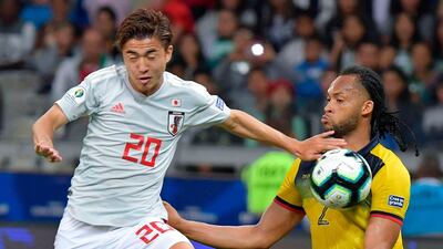 Japan's Hiroki Abe, left, and Ecuador's Arturo Mina vie for the ball. AFP