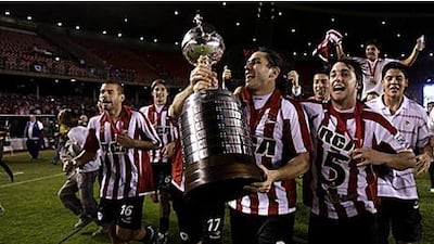 Estudiantes players celebrate with the Copa Libertadores after beating Cruzeiro 2-1 on aggregate.
