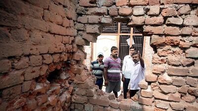 Indian villagers inspect a house damaged by shelling from the Pakistani side of the disputed Kashmir border, at Arnia village, about 45km from Jammu, the winter capital of Kashmir, India, on Tuesday. Jaipal Singh / EPA