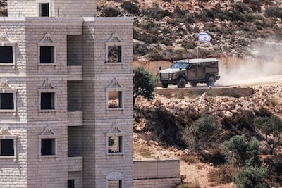 Israeli soldiers arrive at a Palestinian building under construction in Qusra, the West Bank, which has been occupied by Israeli settlers. AFP