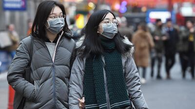 People wear face masks in London, Britain. EPA/ANDY RAIN