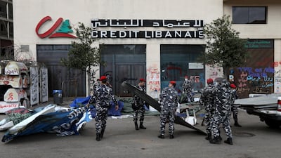 Lebanese security forces remove tents as they clear away a protest camp and reopened roads blocked by demonstrators since protests against the governing elite started in October, in Beirut. REUTERS