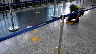 An airport officer places a social distancing sticker in the international arrivals terminal at Ngurah Rai airport in Tuban on Indonesia's resort island of Bali on October 14. AFP