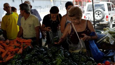 A woman selects peppers at a stall in Caracas, Venezuela October 8, 2018. Monthly inflation rose to 233 per cent in September from 223 per cent in August. Reuters