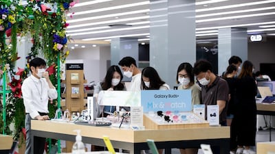 Customers wearing protective masks try out Samsung Galaxy Tab tablet devices at the company's Digital Plaza store in Seoul, South Korea. Bloomberg