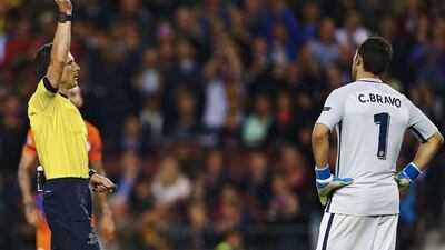 Referee Milorad Mazic, left, shows a red card to Manchester City’s goalkeeper Claudio Bravo. Alejandro Garcia / EPA