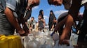Displaced Palestinians gather to fetch water in Gaza. AFP