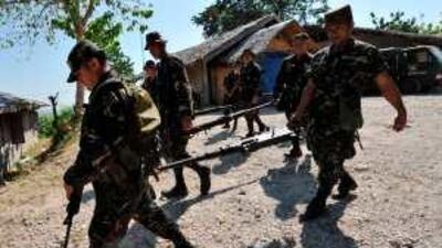 Soldiers carry machine guns unearthed yesterday at a property believed to belong to the Ampatuan clan.