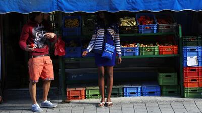 In this Friday, Nov. 16, 2018, migrants stand at a market stall in central Nicosia, Cyprus. Cyprus was not seen as an attractive destination for migrants seeking shelter and a new life in Europe, but that has changed as other nations in Europe have shut their borders and the economic situation has slowly improved for this small island nation.(AP Photo/Petros Karadjias)