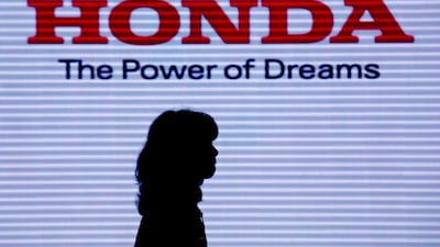A visitor walks under the logo of Honda Motor Co at the company headquarters in Tokyo, Japan. Honda announced it will quit Formula One to focus on carbon neutrality at the end of the 2021 season. EPA