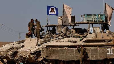 Israeli soldiers and an armoured personnel carrier on the Israeli side of the border with Gaza. Reuters
